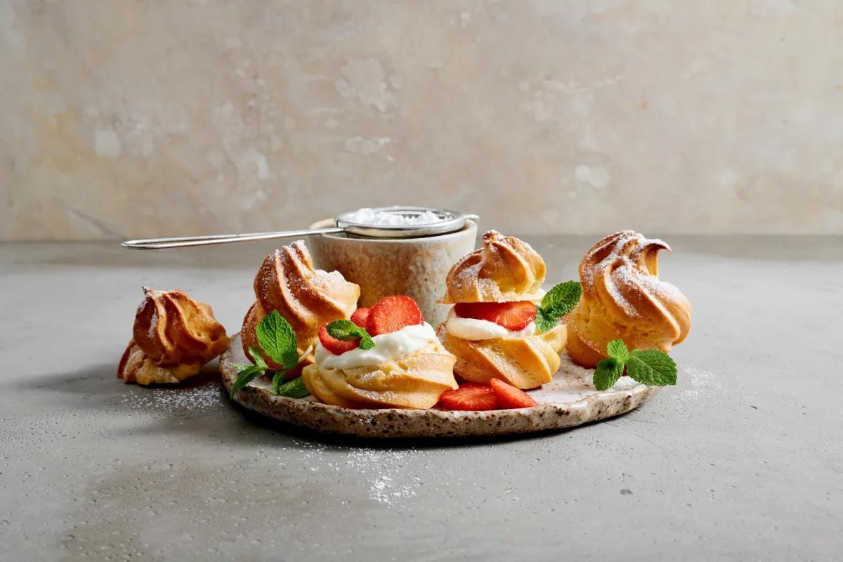 Petits choux aux baies. Das fertige Gericht schön angerichtet und fotografiert aus Vogelperspektive (Food Fotografie). Serviervorschlag, Original Tiptopf Rezept, aus dem bekanntesten Kochbuch der Schweiz